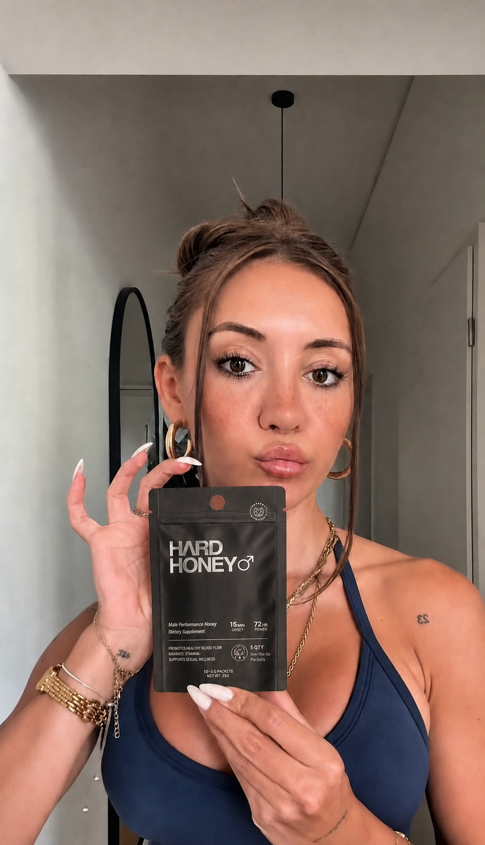 Woman holding a Hard Honey pouch indoors